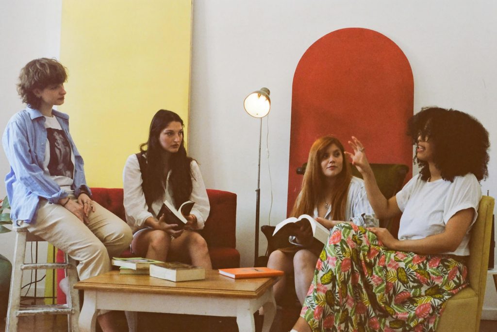 A group of ladies sitting around a coffee table discussing a book